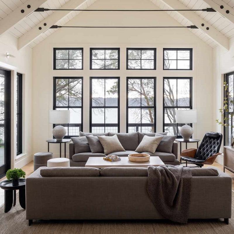 Bright American modern living room with large windows and neutral furniture representing a clean indoor air environment for asthma-friendly homes.