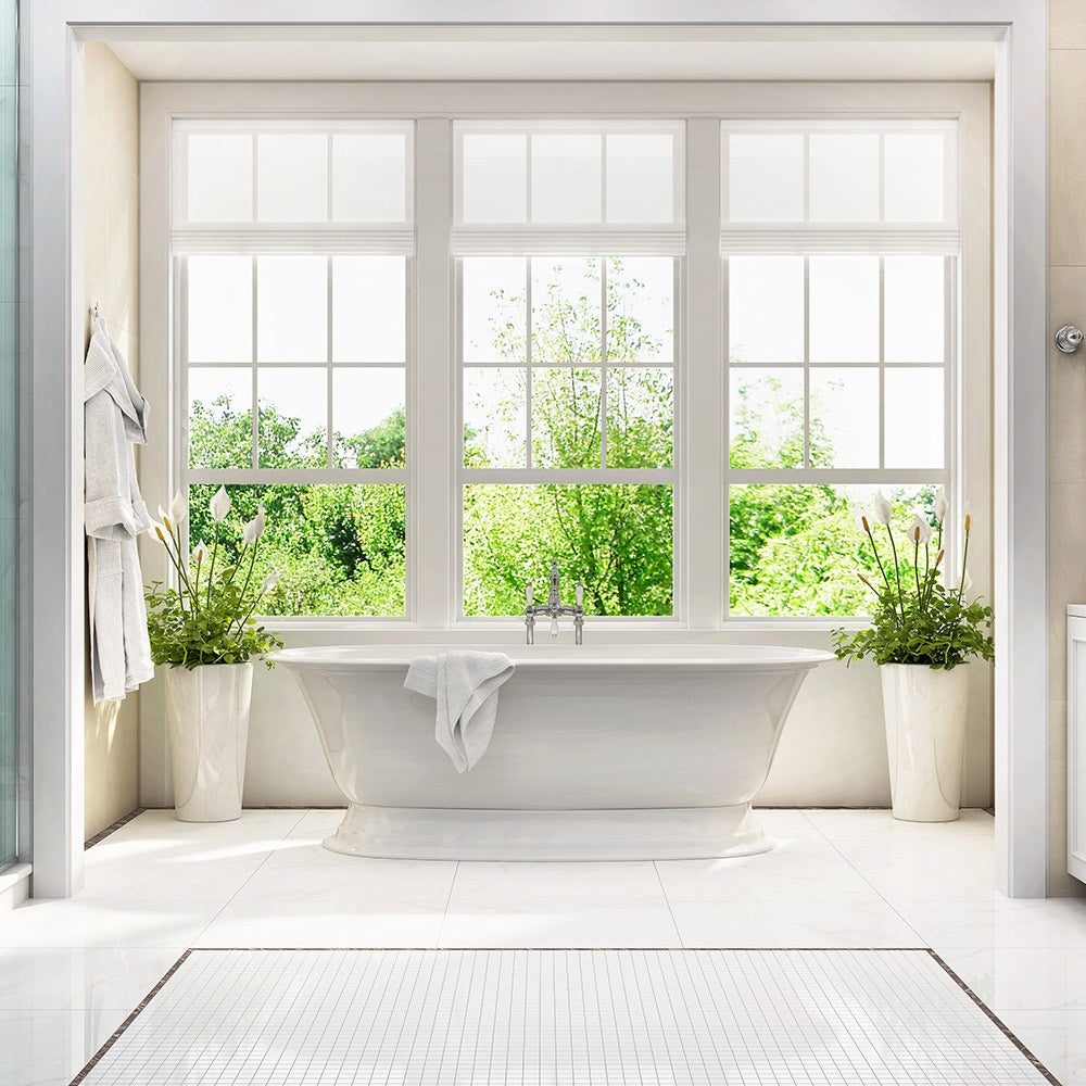 Bathroom with a freestanding bathtub, large window, and potted plants.